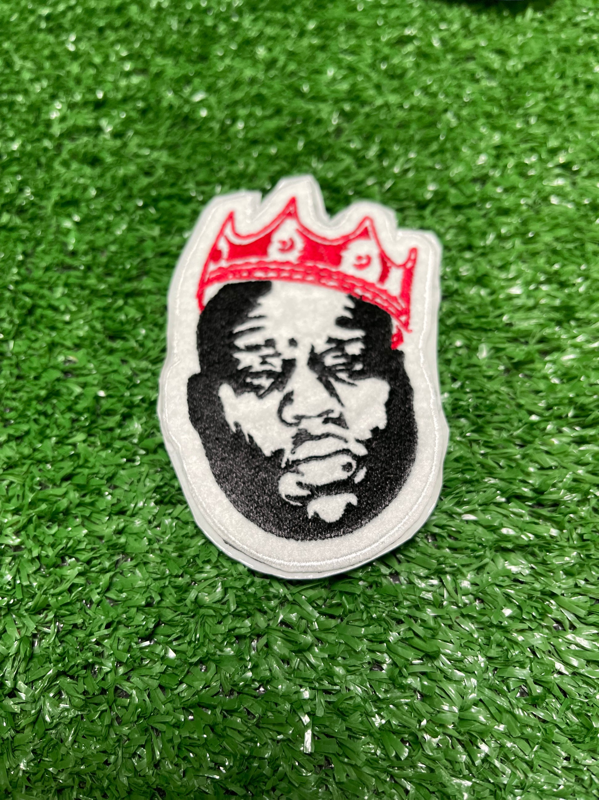 Custom embroidered patch of the Notorious BIG wearing a red crown stitched in black, white, and red thread. Custom embroidered patch of the Notorious BIG wearing a gold crown stitched in black, white, and red thread.