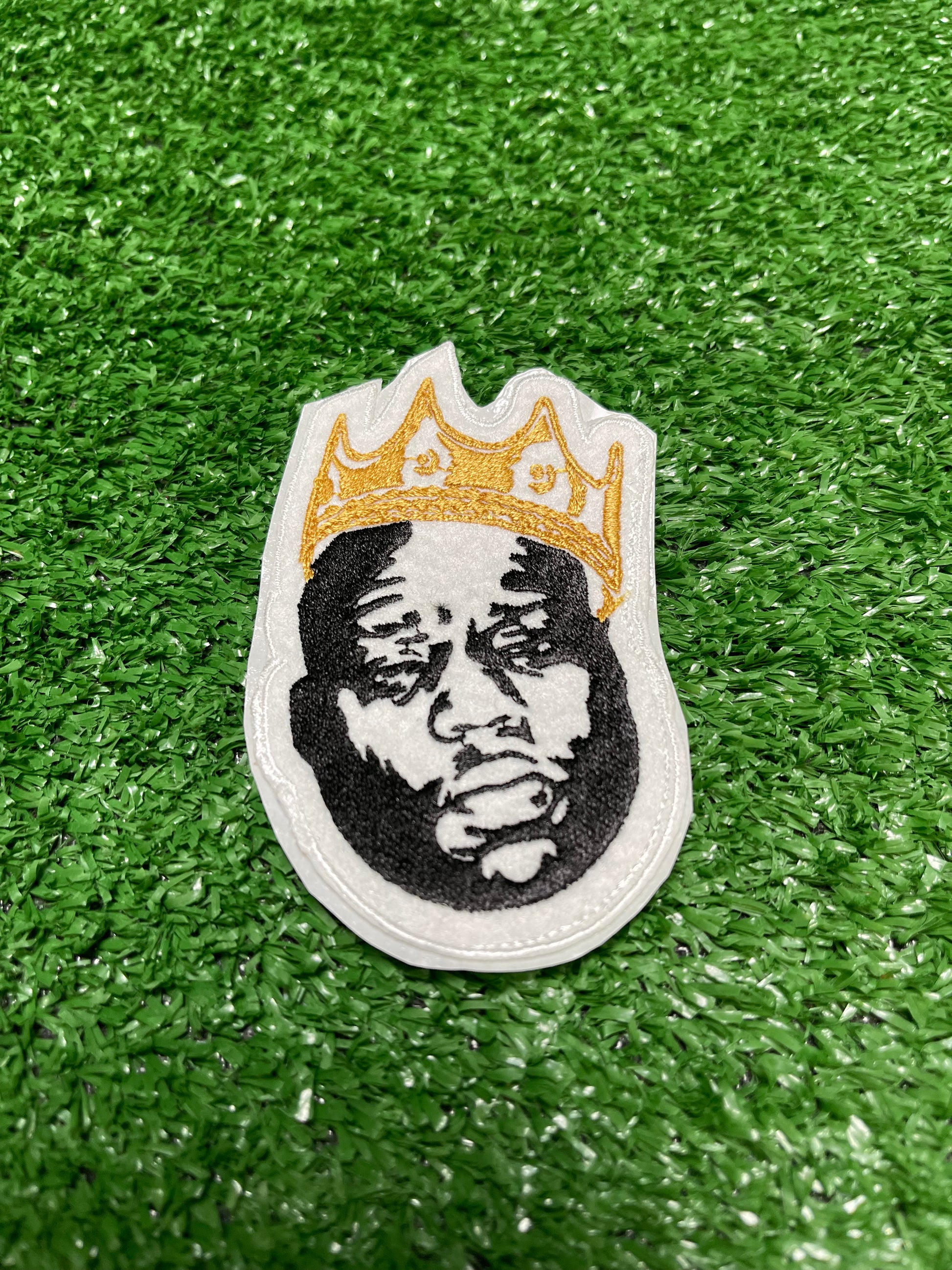 Custom embroidered patch of the Notorious BIG wearing a red crown stitched in black, white, and red thread. Custom embroidered patch of the Notorious BIG wearing a gold crown stitched in black, white, and red thread.