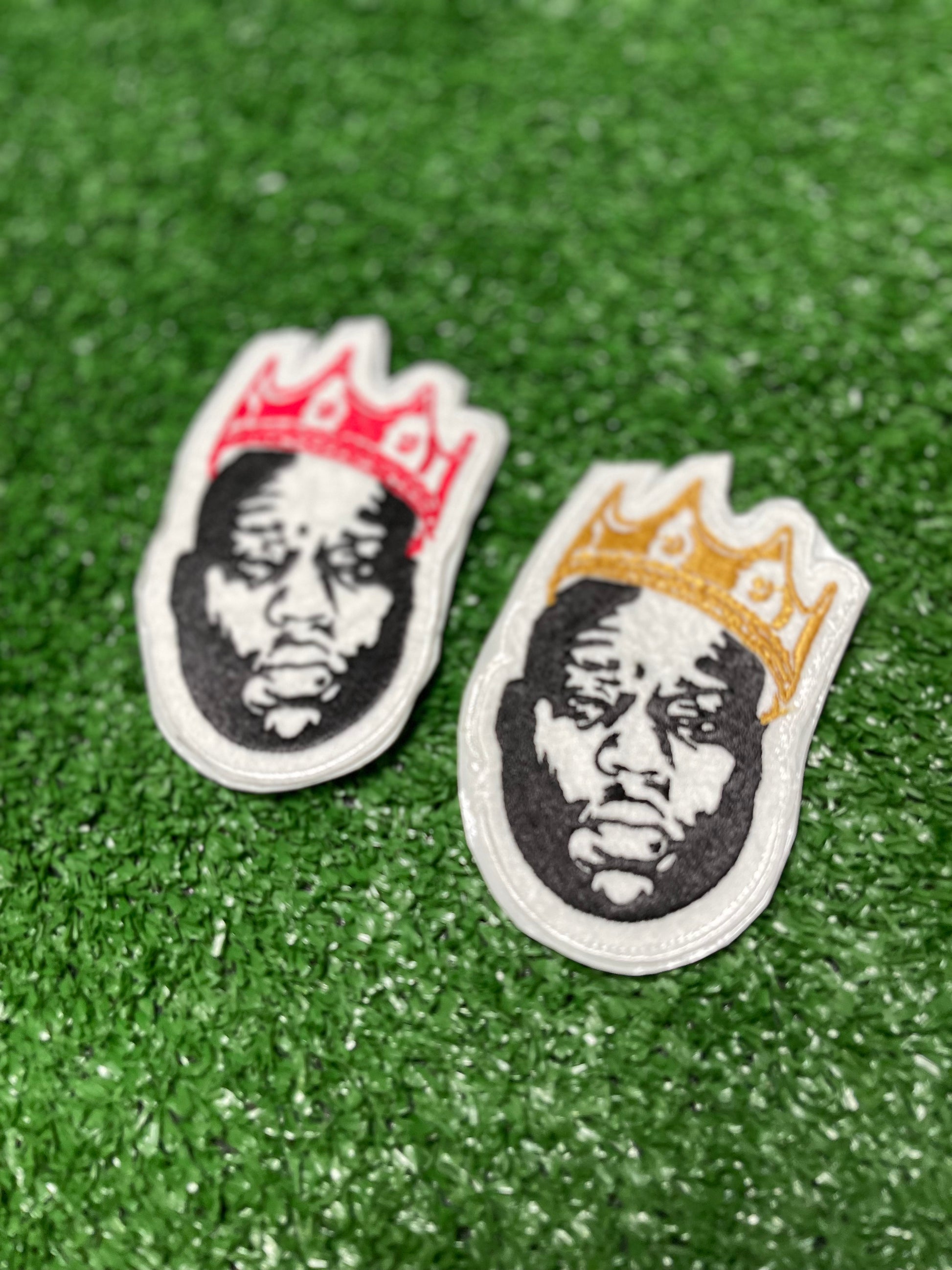 Custom embroidered patch of the Notorious BIG wearing a red crown stitched in black, white, and red thread. Custom embroidered patch of the Notorious BIG wearing a gold crown stitched in black, white, and red thread.