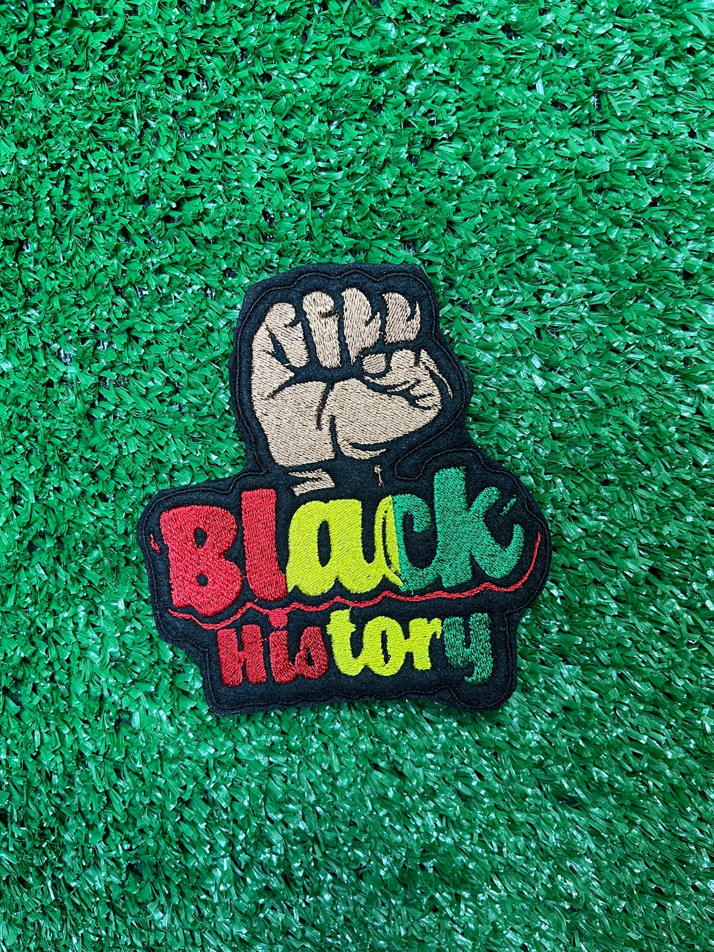 Bold and empowering iron-on patch featuring a raised fist symbol. Perfect for celebrating Black history and expressing solidarity, this high-quality embroidered patch adds a powerful statement to jackets, backpacks, hats, and other clothing items.