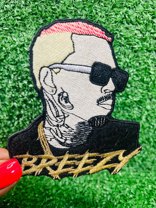 Embroidered patch of Chris Brown Breezy with tattoos and sunglasses on a green grass background