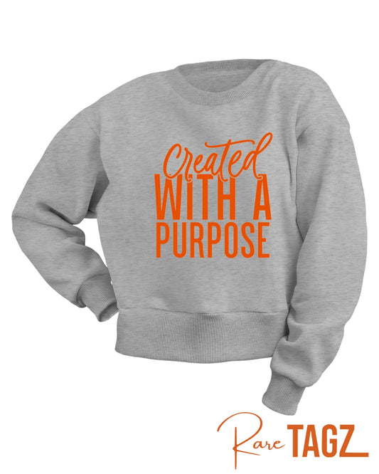 Soft sweatshirt featuring the phrase Created with a Purpose in stylish lettering, perfect for casual wear and expressing personal motivation.