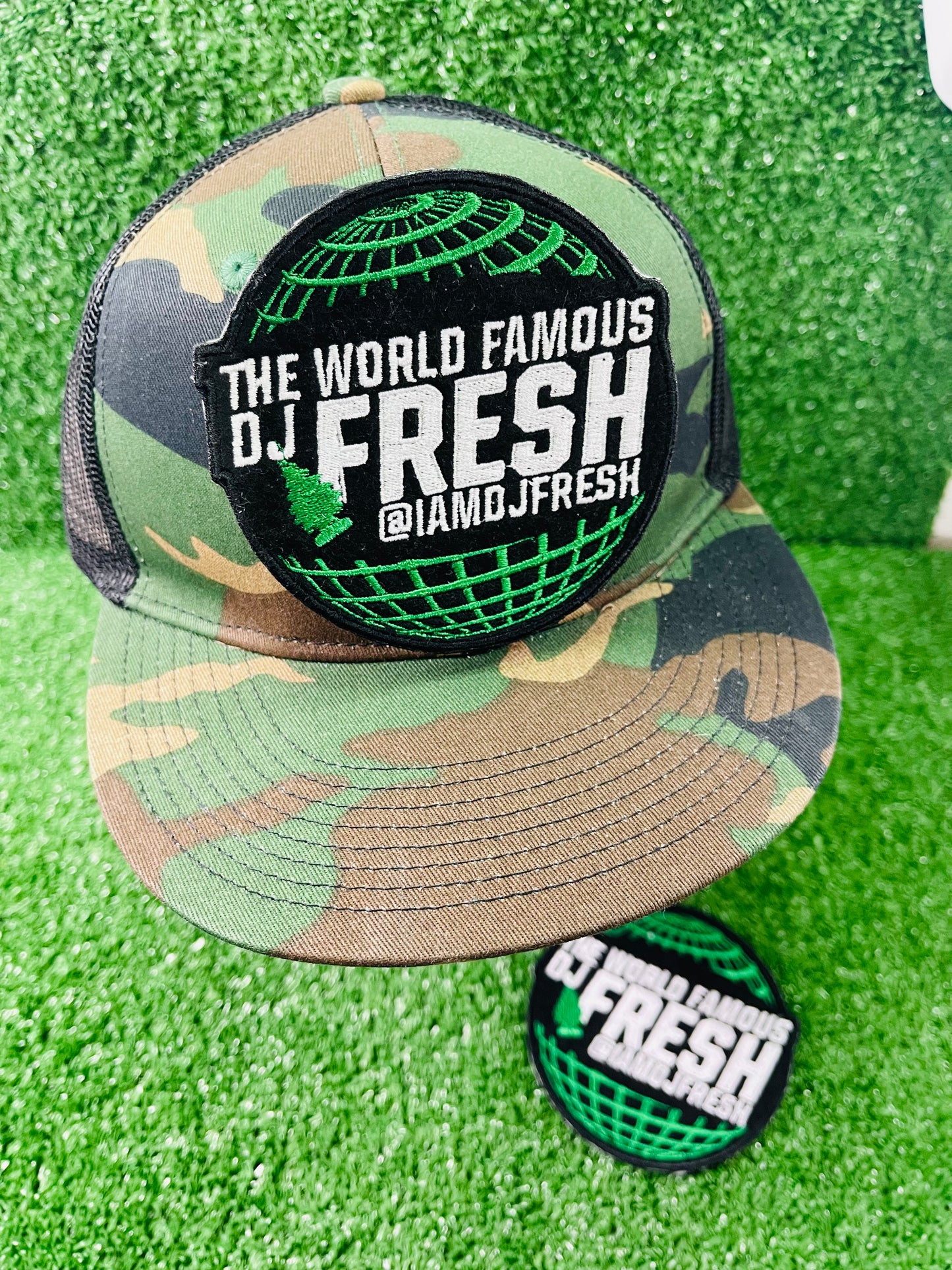 Camouflage cap with 'The World Famous DJ Fresh' logo on a green background