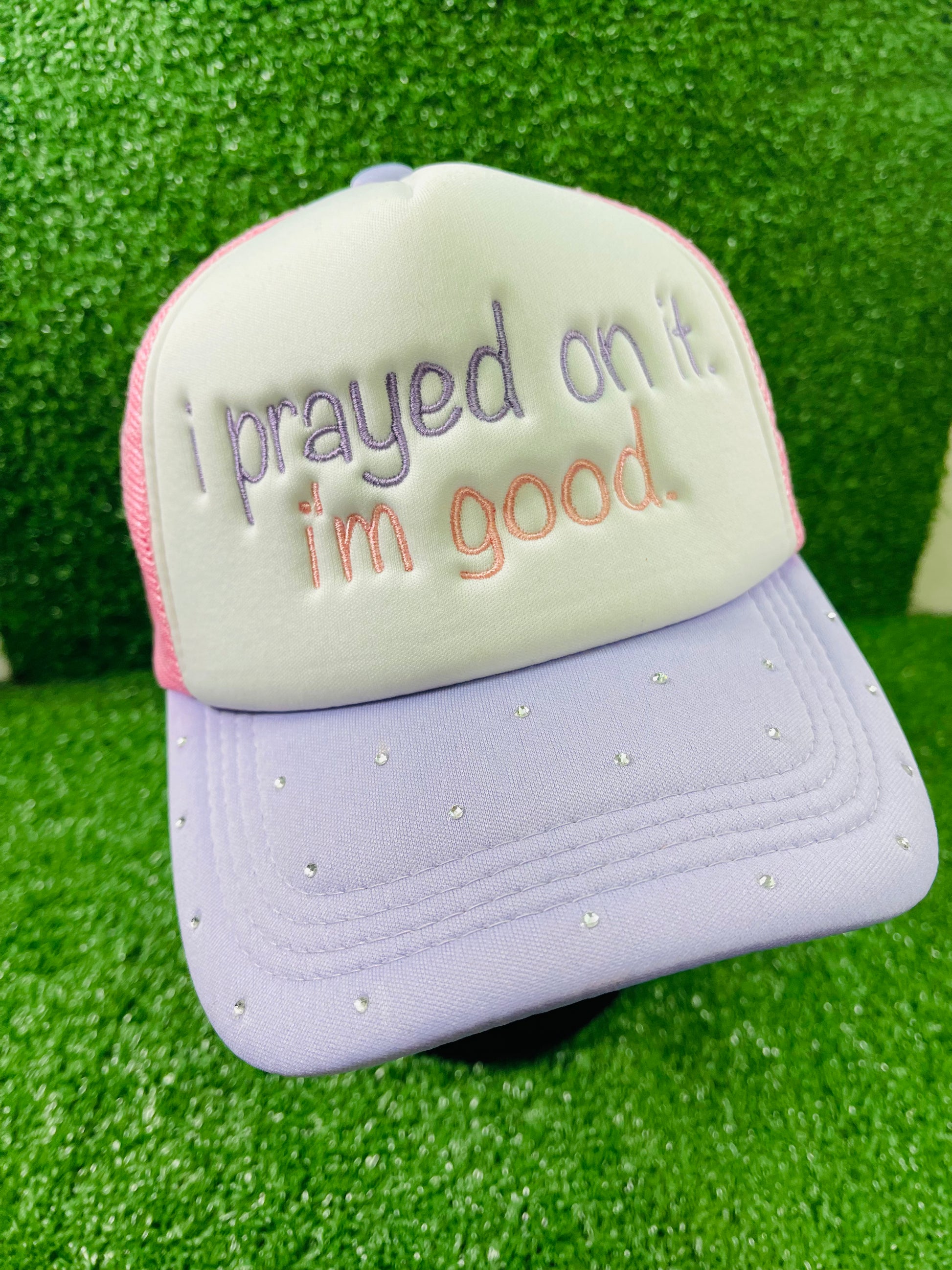 Custom embroidered pink and purple trucker hat with the phrase I prayed on it. I'm good. stitched on the front in purple and pink thread. The lavender brim is embellished with small rhinestones, adding a sparkly touch.