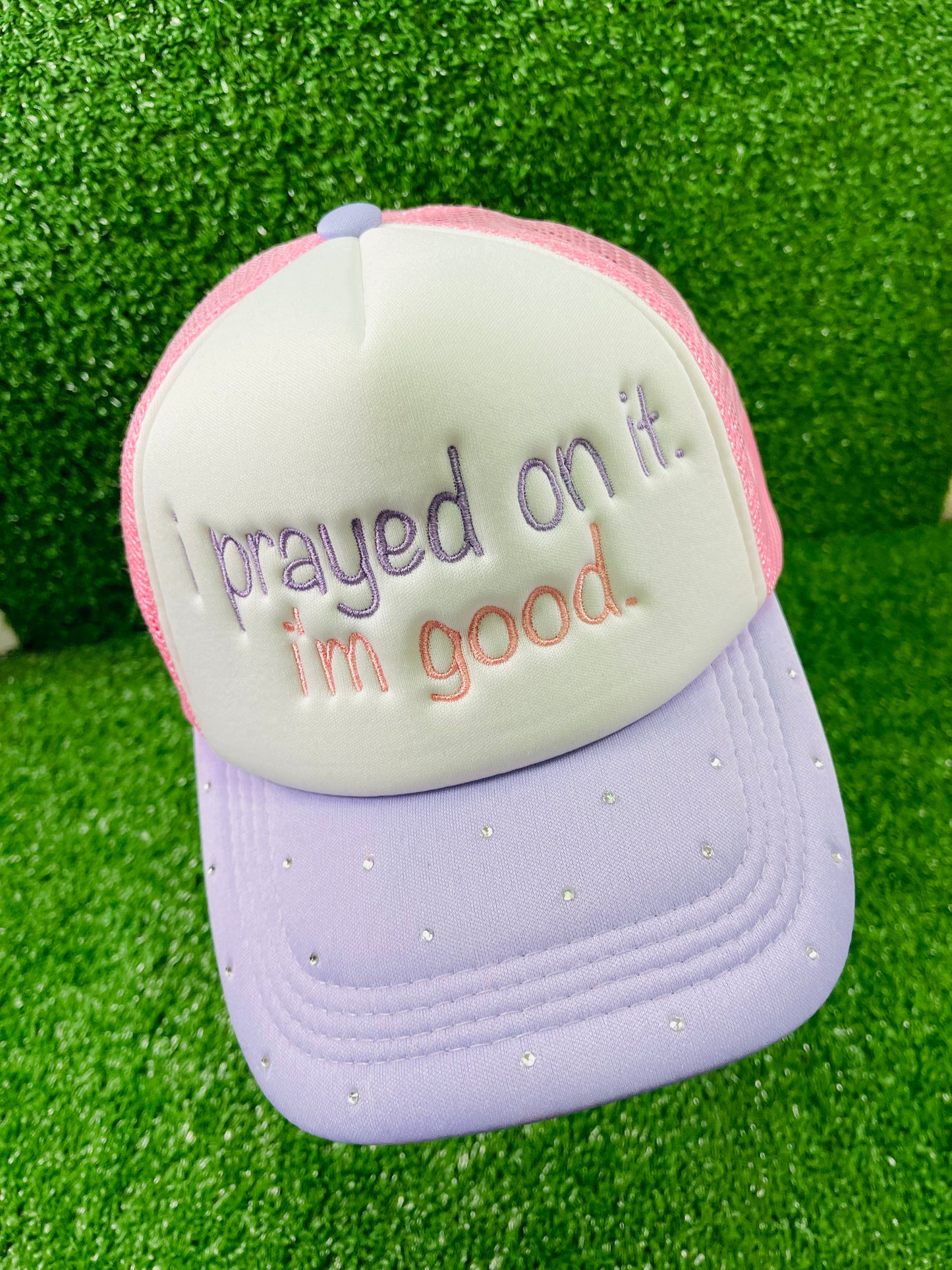 Custom embroidered pink and purple trucker hat with the phrase I prayed on it. I'm good. stitched on the front in purple and pink thread. The lavender brim is embellished with small rhinestones, adding a sparkly touch.