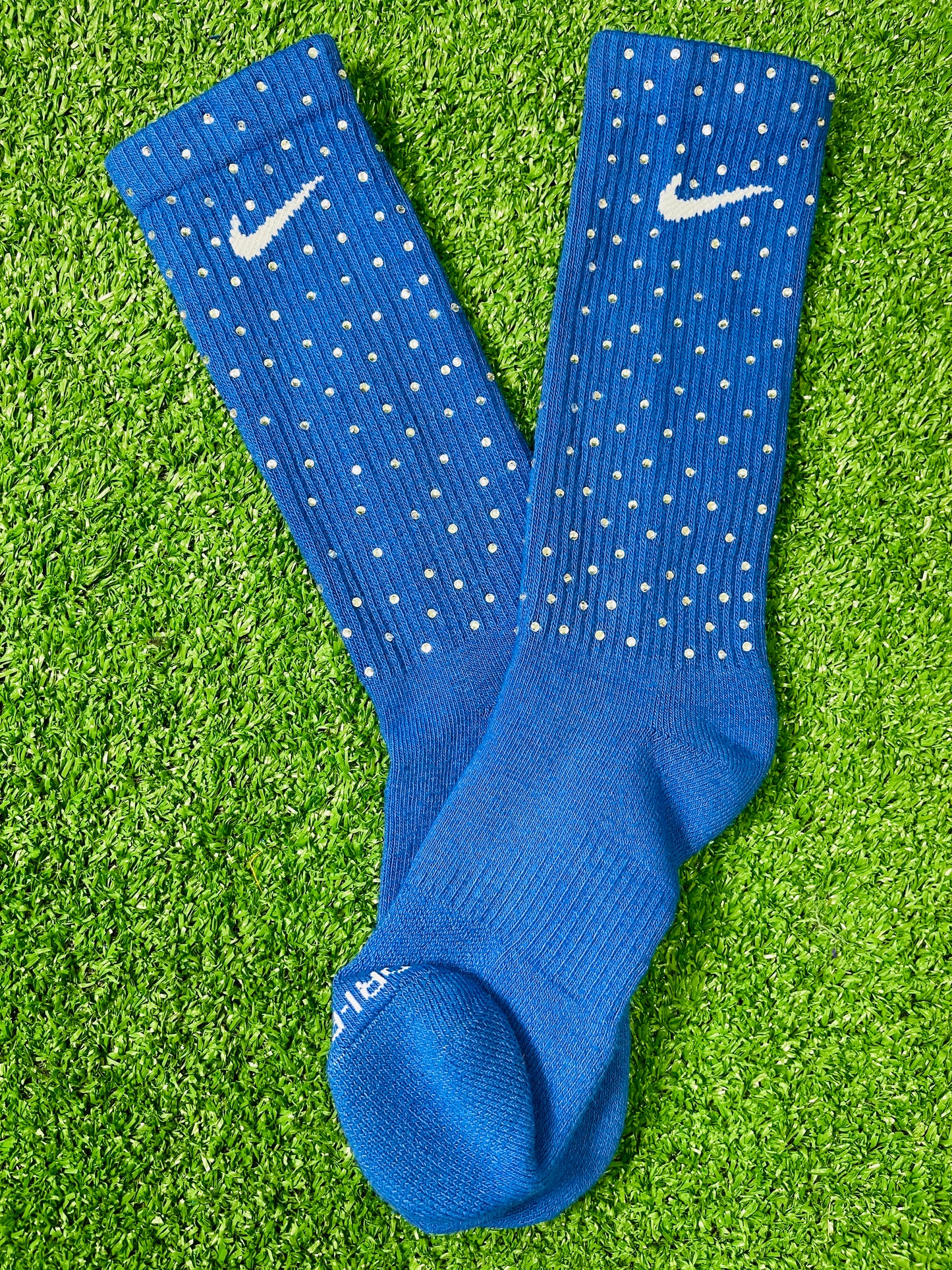 Blue Nike socks embellished with sparkling rhinestones, adding a touch of bling and style.  The socks feature a bold blue color with rhinestones carefully placed for a dazzling effect, perfect for elevating any sneaker look.