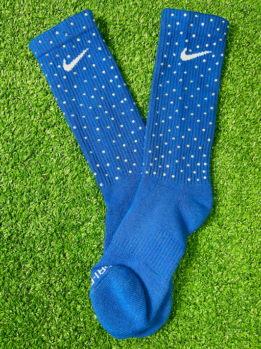Blue Nike socks embellished with sparkling rhinestones, adding a touch of bling and style.  The socks feature a bold blue color with rhinestones carefully placed for a dazzling effect, perfect for elevating any sneaker look.