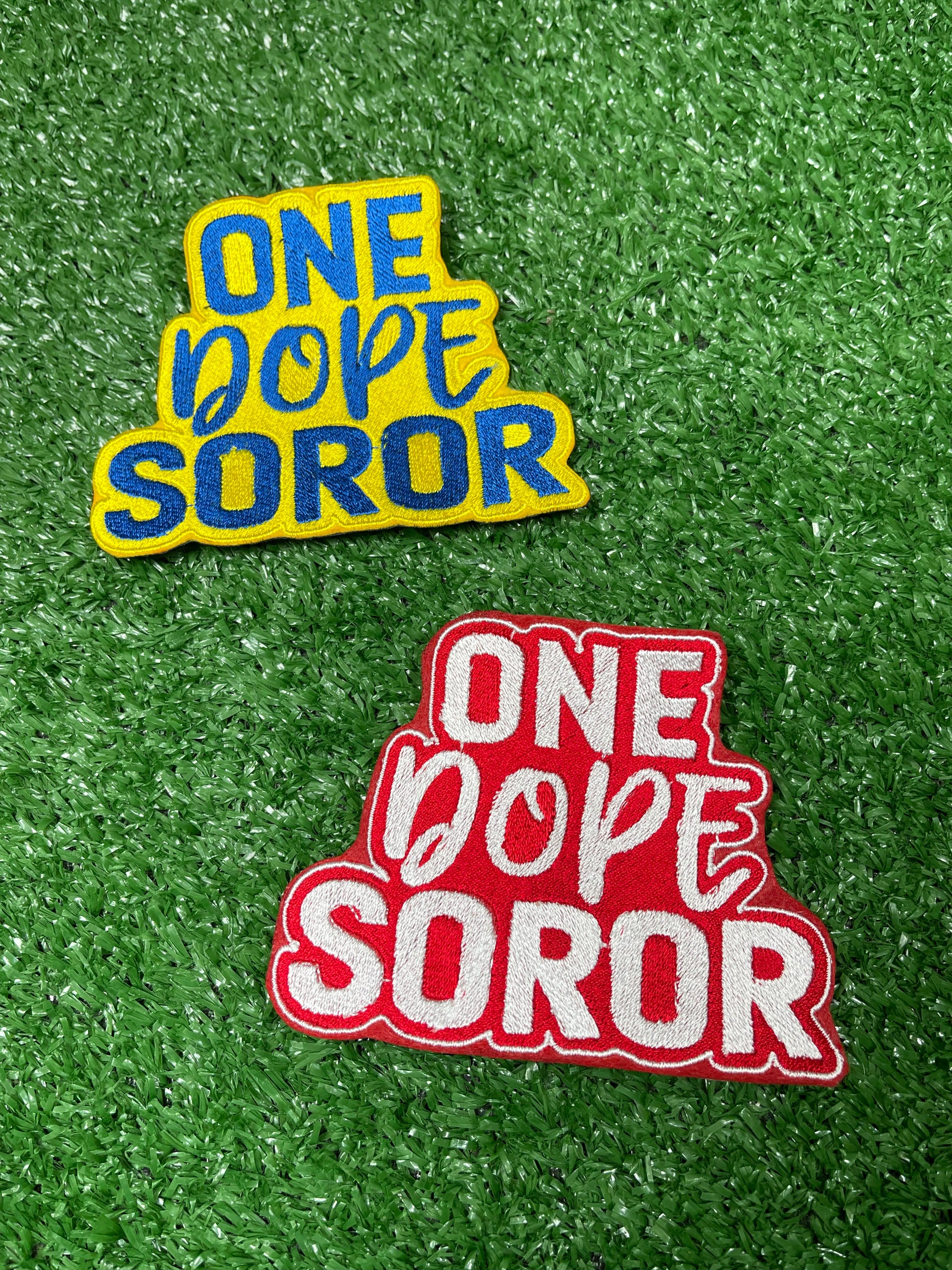 Embroidered patch with bold red and white lettering that says One Dope Soror on a green grass background.