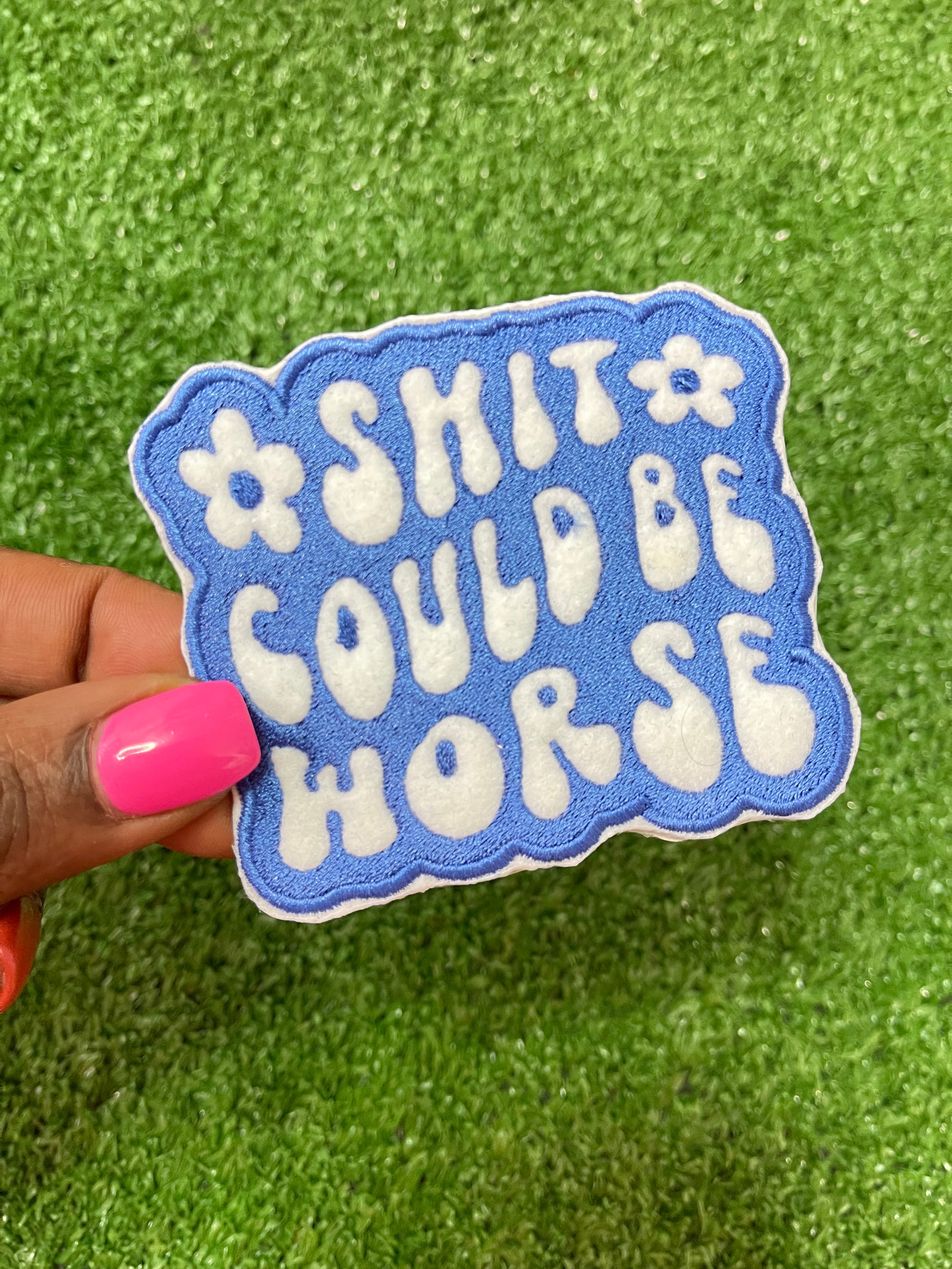 Embroidered patch with the phrase Shit Could be Worse in bold white lettering on a blue background. The design is simple yet impactful, adding a touch of humor and resilience to any jacket, backpack or trucker hat.