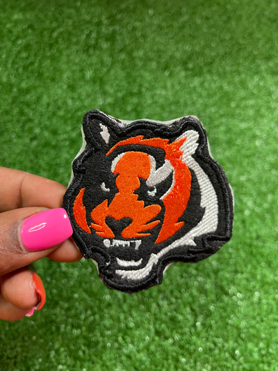 Embroidered Bengal Tiger iron-on patch featuring a detailed and vibrant design of a majestic Bengal Tigers face. Perfect for jackets, backpacks, hats, and clothing. Embroidered iron-on patch featuring the Bengals logo with bold colors and stitching. Cincinnati