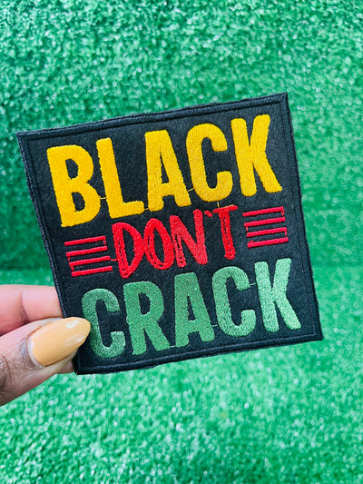 Embroidered patch with the bold text reading Black Don't Crack in yellow, red, and green on a black background.