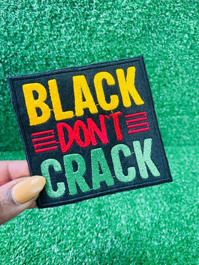 Embroidered patch with the bold text reading Black Don't Crack in yellow, red, and green on a black background.