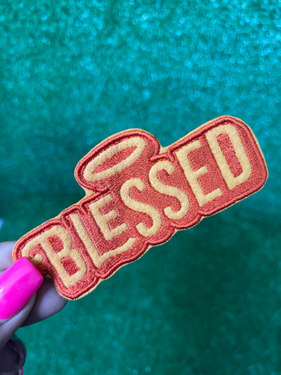 Elegant iron-on patch featuring the word 'Blessed' in stylish, cursive lettering. Perfect for adding a touch of positivity and inspiration to jackets, backpacks, hats, and other clothing items.