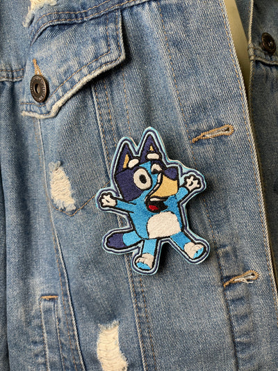 Bluey cartoon character iron-on patch with vibrant colors and playful design.