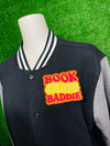 Bold and trendy iron-on patch featuring the phrase 'Book Club Baddie' in stylish lettering. Perfect for book lovers, this high-quality embroidered patch showcases vibrant colors and intricate stitching, ideal for adding a literary flair to jackets, backpacks, hats, and other clothing items.