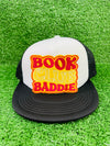 Bold and trendy iron-on patch featuring the phrase 'Book Club Baddie' in stylish lettering. Perfect for book lovers, this high-quality embroidered patch showcases vibrant colors and intricate stitching, ideal for adding a literary flair to jackets, backpacks, hats, and other clothing items.