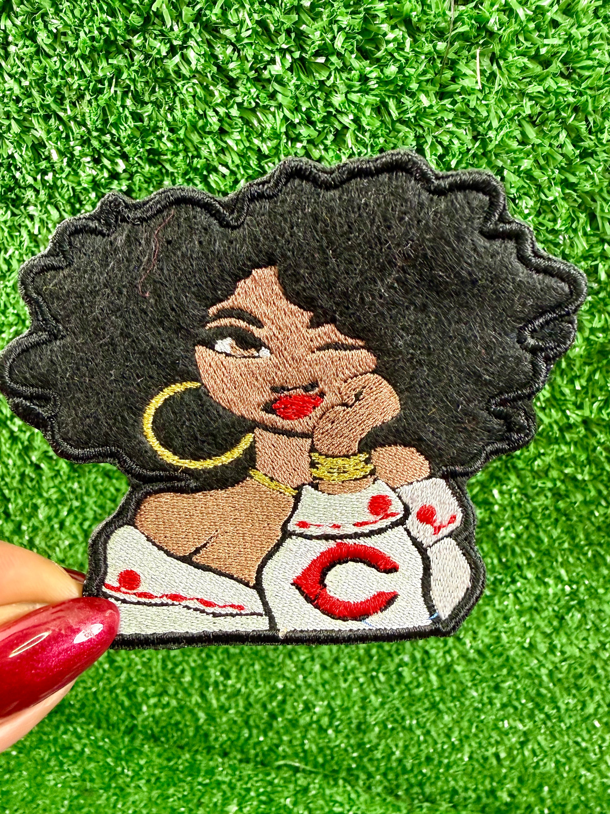 Embroidered patch of a woman with a Cincinnati Reds logo on her shirt. Game Day opening day patch