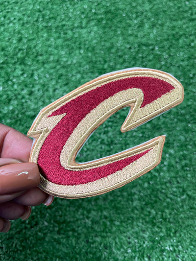 A close-up of a Cleveland Cavaliers patch featuring the teams letter C. Perfect for add a bold, sporty touch to jackets, trucker hats, or bags.