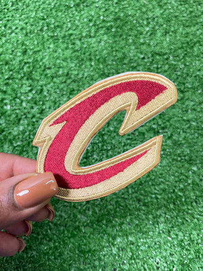 A close-up of a Cleveland Cavaliers patch featuring the teams letter C. Perfect for add a bold, sporty touch to jackets, trucker hats, or bags.