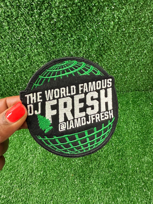 Round patch with 'The World Famous DJ Fresh' text held over a green background