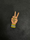 Custom embroidered Deuces patch depicting a hand with two fingers raised in a peace sign adorned with bangles and matching nails.