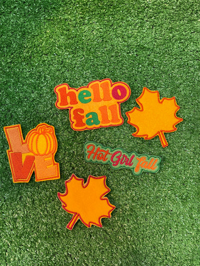 A set of 5 fall themed patches including Hello Fall, Hot Girl Fall, and Love with a pumpkin as the O. The bundle also features two leaf designs.