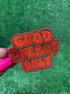 Good Energy patch with bold embroidered letters on a brown background.