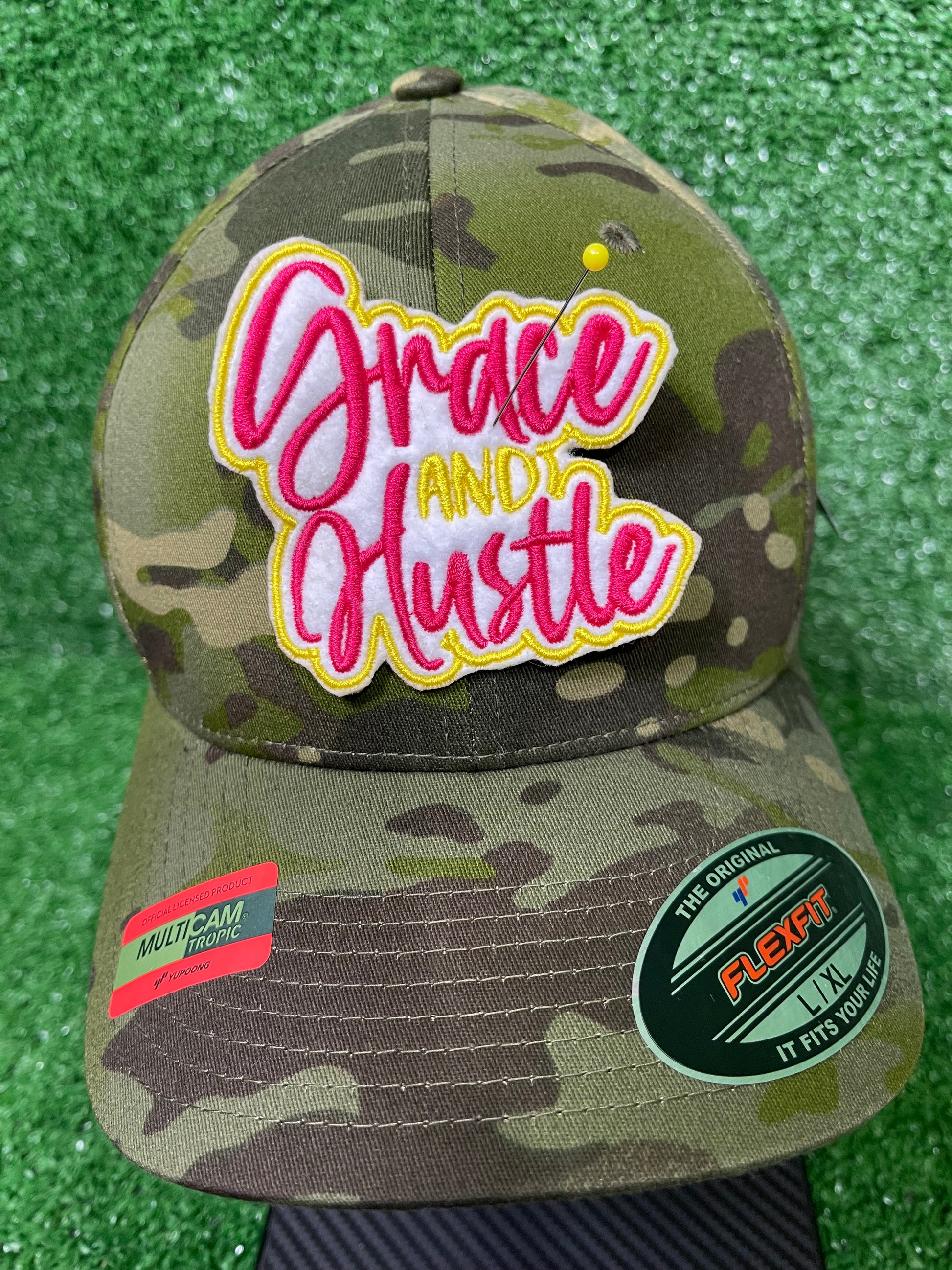 Grace and Hustle embroidered iron-on patch in bold pin k and yellow thread with white background. Motivational iron-on patch for jackets, bags, and custom appearel. 
