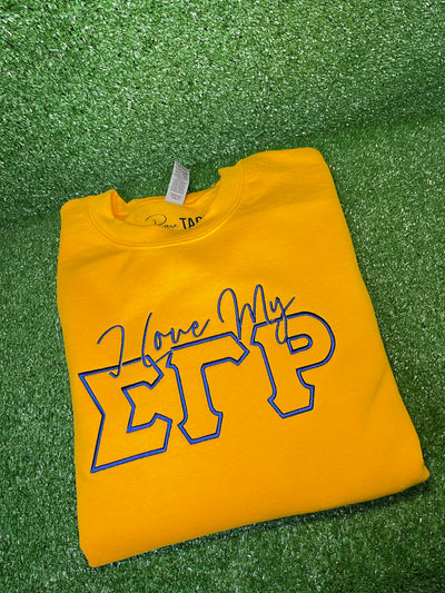 I Love My SGRho Embroidered Sweatshirt - This high-quality sweatshirt features a beautifully embroidered 'I Love My SGRho' design on the front. Made from a soft and durable blend of cotton and polyester, it offers a classic fit with a comfortable crew neck. Perfect for chilly days, casual outings, or chapter meetings, this stylish sweatshirt showcases your Sigma Gamma Rho pride with elegance.