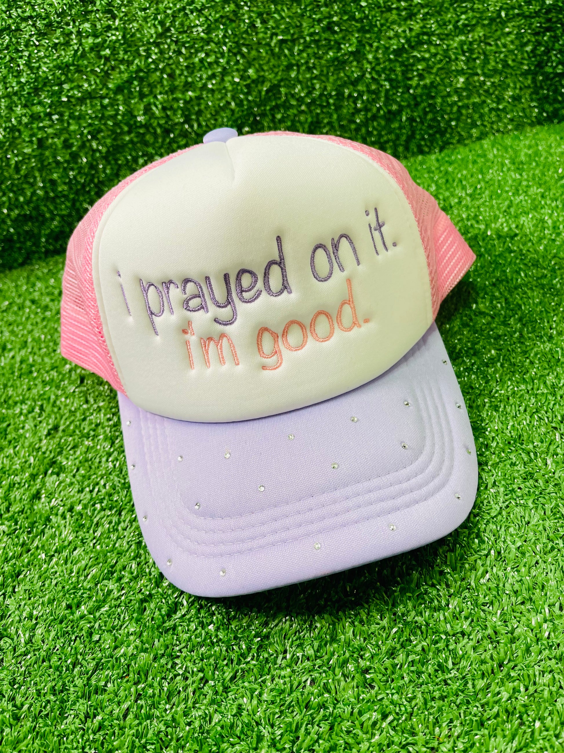 Custom embroidered pink and purple trucker hat with the phrase I prayed on it. I'm good. stitched on the front in purple and pink thread. The lavender brim is embellished with small rhinestones, adding a sparkly touch. 