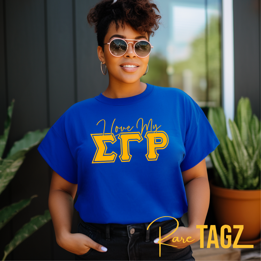 A woman wearing a blue t-shirt with 'I Love My SGRho' printed in yellow text.