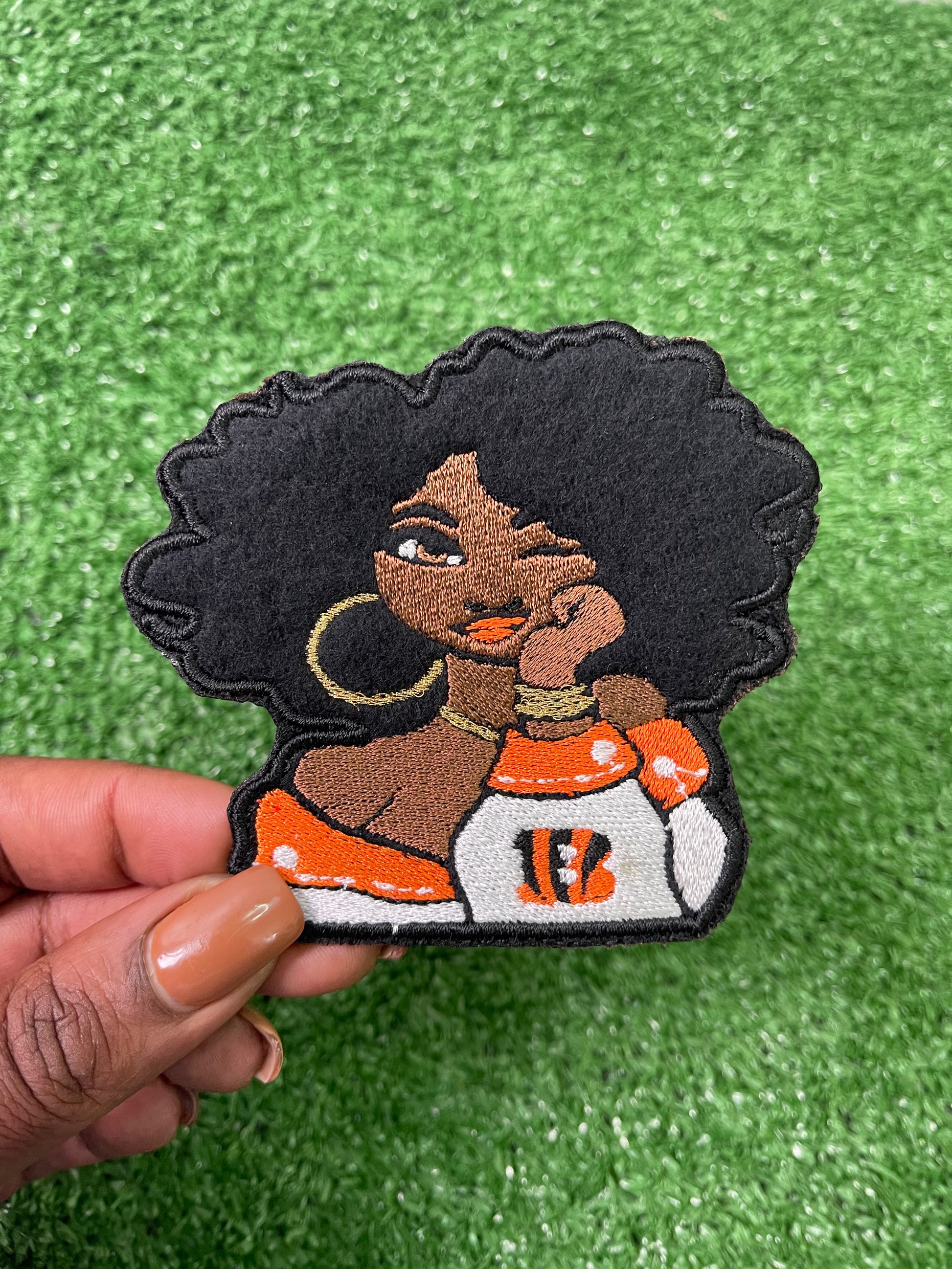 Stylish NFL Diva Iron-On Patches featuring a confident curly hair woman wearing the colors of the Bengals sports team. 
