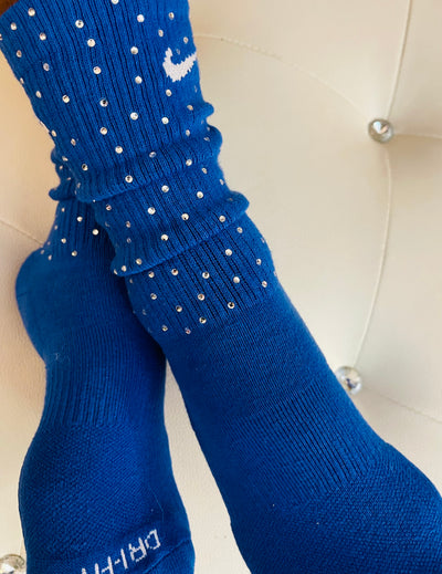 Blue Nike socks embellished with sparkling rhinestones, adding a touch of bling and style.  The socks feature a bold blue color with rhinestones carefully placed for a dazzling effect, perfect for elevating any sneaker look.