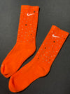 Orange Nike socks embellished with sparkling rhinestones, adding a touch of bling and style.  The socks feature a bold orange color with rhinestones carefully placed for a dazzling effect, perfect for elevating any sneaker look.