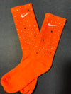 Orange Nike socks embellished with sparkling rhinestones, adding a touch of bling and style.  The socks feature a bold orange color with rhinestones carefully placed for a dazzling effect, perfect for elevating any sneaker look.