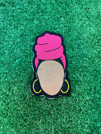 Embroidered patch featuring a faceless Nubian queen with a vibrant pink headwrap and yellow hoop earrings on a black background.