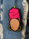 Embroidered patch featuring a faceless Nubian queen with a vibrant pink headwrap and yellow hoop earrings on a black background.