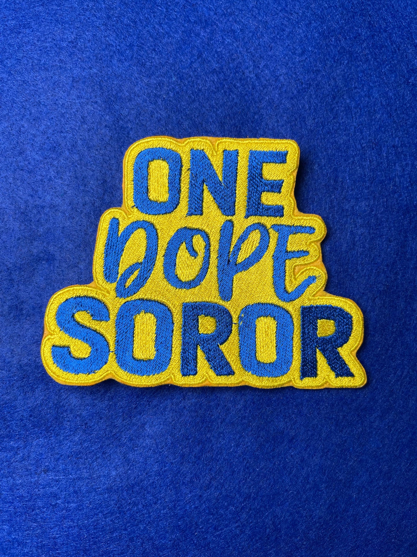 Embroidered patch with bold blue and yellow lettering that says One Dope Soror on a white background.