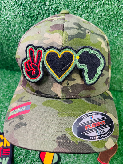 A colorful, embroidered patch featuring a red peace sign a yellow heart, and the silhouette of Africa in green and black. The design symbolizes unity, love, and pride in African heritage.