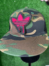 Detailed view of a pink Adidas iron-on patch with the classic trefoil logo and three stripes, perfect for adding a stylish, personalized touch to clothing.