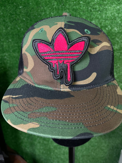 Detailed view of a pink Adidas iron-on patch with the classic trefoil logo and three stripes, perfect for adding a stylish, personalized touch to clothing.