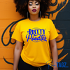 A vibrant yellow/gold shirt featuring a stylish 'Pretty Poodle' graphic. The text is elegantly displayed in bright royal blue, creating a stunning contrast against the gold/yellow background.