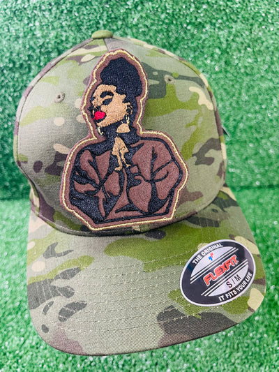 An embroidered patch featuring a black woman with a high puff hairstyle, bold red lips and a serene expression.