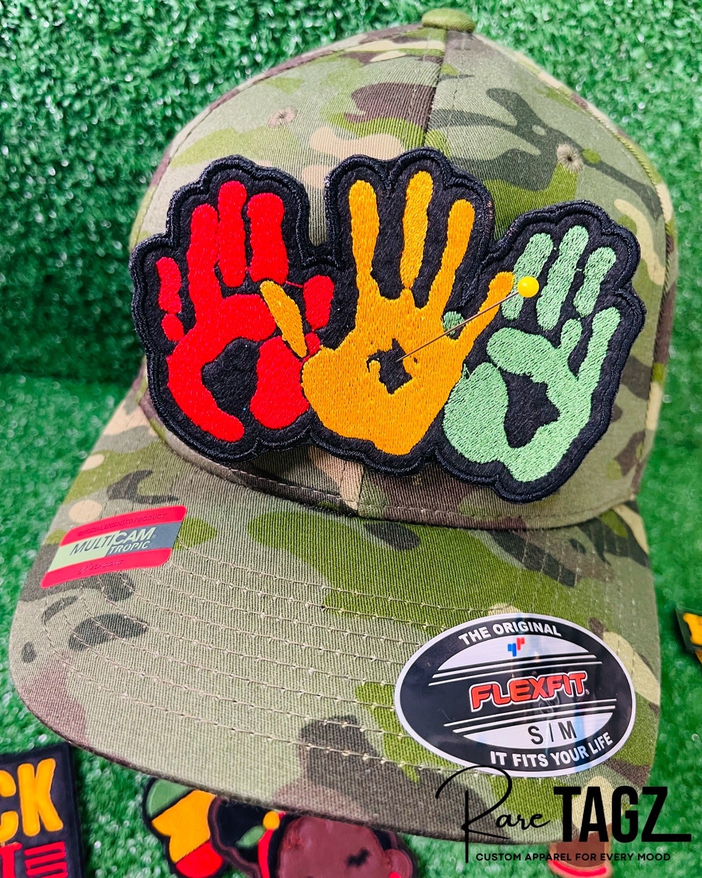 A vibrant embroidered patch featuring three overlapping handprints in red, yellow, green, symbolizing unity. pride, and heritage. The patch has a bold black outline that enhances the striking design. Perfect for celebrating Black culture and adding a meaningful touch to clothing or accessories. 